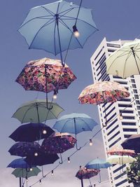 Low angle view of illuminated lanterns hanging against sky