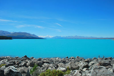 Panoramic view of sea and mountains against blue sky