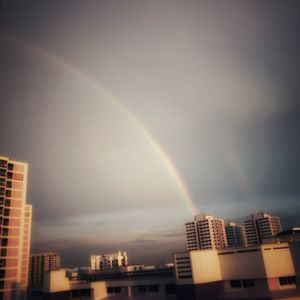 Low angle view of rainbow over buildings in city