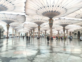 Group of people walking on tiled floor in city