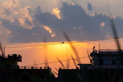 Low angle view of silhouette buildings against sky at sunset