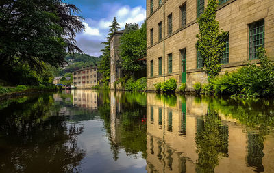 Scenic view of lake by buildings against sky