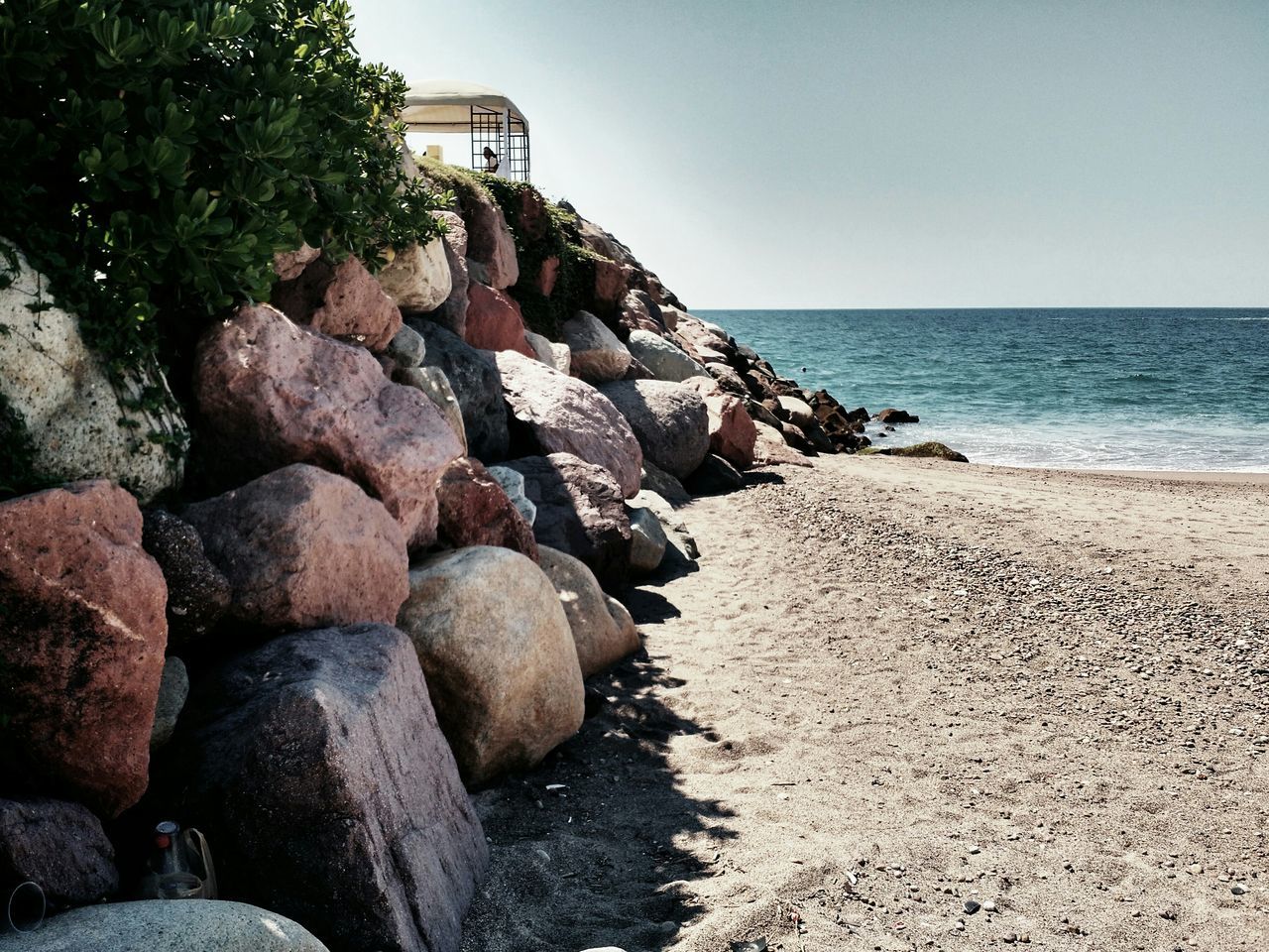 sea, horizon over water, beach, water, clear sky, shore, rock - object, tranquility, tranquil scene, scenics, sand, nature, beauty in nature, sky, stone - object, coastline, rock formation, rock, sunlight, day