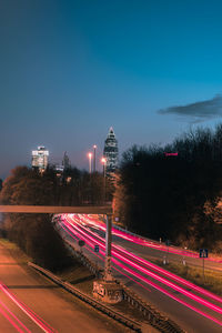 Light trails on road against sky at night