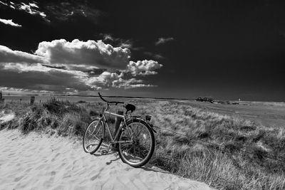 Bicycle on landscape against sky