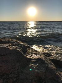 Close-up of sea against clear sky at sunset