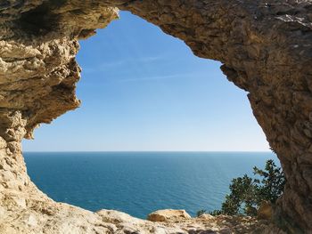 Rock formations by sea against sky