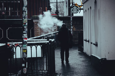 Rear view of man walking on street in city