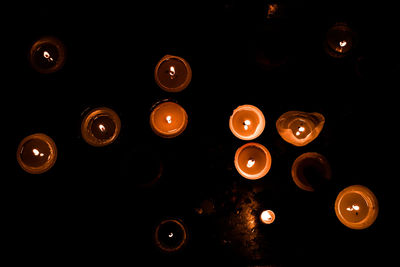 Close-up of illuminated lighting equipment against black background