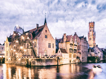 Buildings in city against cloudy sky