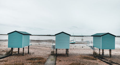 Beach huts by sea against sky