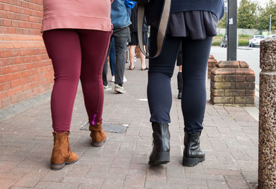 Low section of women standing on footpath