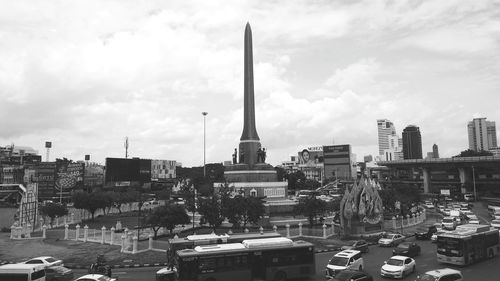 Traffic on road by buildings against sky