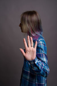 Midsection of woman standing against gray background