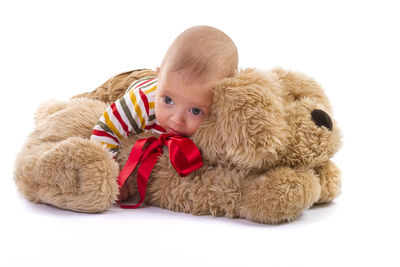 Portrait of boy with stuffed toy against white background