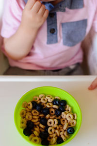 High angle view of toddler boy having breakfast on high chair