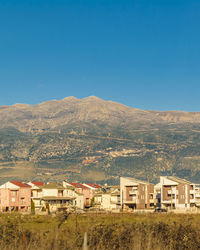 Buildings in town against clear blue sky