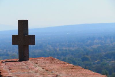Stone cross on mountain against sky