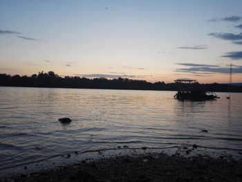 Boats in sea at sunset