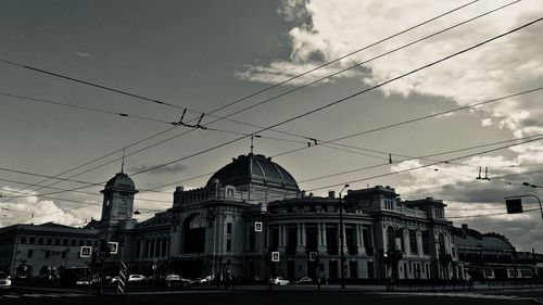 Low angle view of buildings in city against cloudy sky