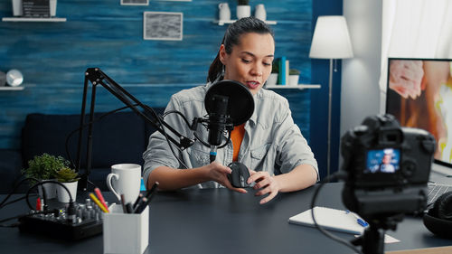 Young woman using mobile phone at desk in office