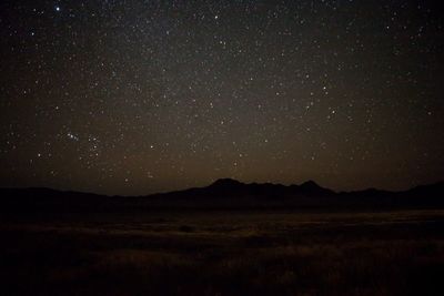 Scenic view of landscape against star field at night