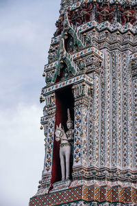 Low angle view of buddha statue against building