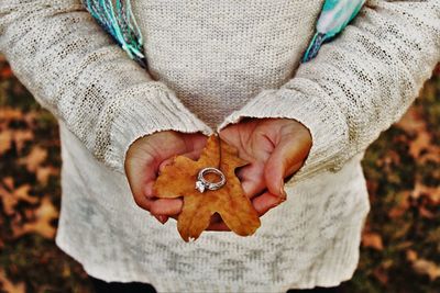 Close-up of hand holding autumn leaf