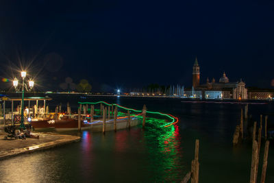 Illuminated bridge over river at night