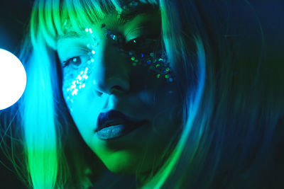 Portrait of woman looking at illuminated nightclub