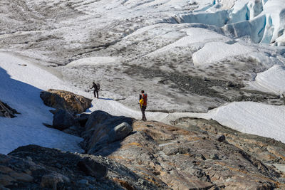 Full length of hikers standing on mountain during winter