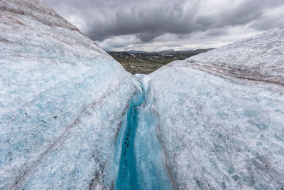 Scenic view of waterfall against sky during winter