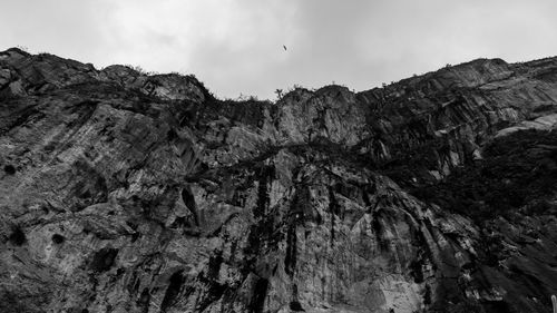 Low angle view of rocky mountains against sky