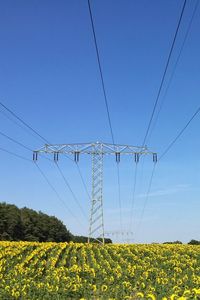 Electricity pylon on field against clear sky