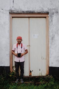 Portrait of man standing against closed door