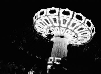 Low angle view of illuminated ferris wheel against sky at night