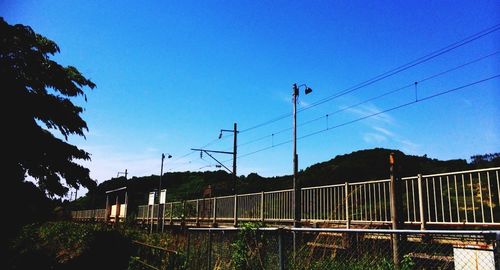 Power lines against clear blue sky