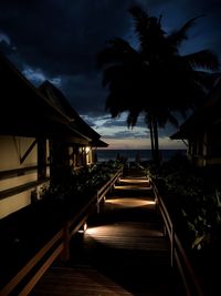 Illuminated boardwalk at beach during night