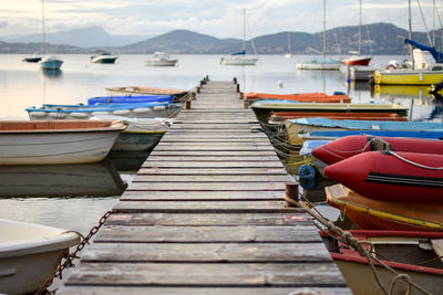 Boats moored at harbor against sky