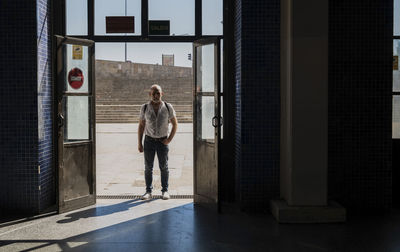 Full length of man standing at the entrance of a station in city