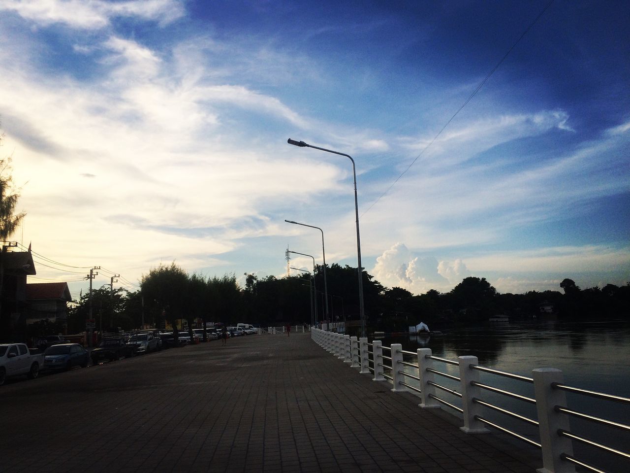 EMPTY FOOTPATH BY PIER AGAINST SKY