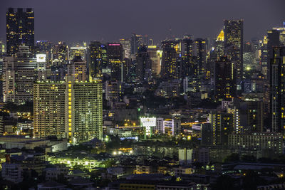 Illuminated buildings in city against sky at night