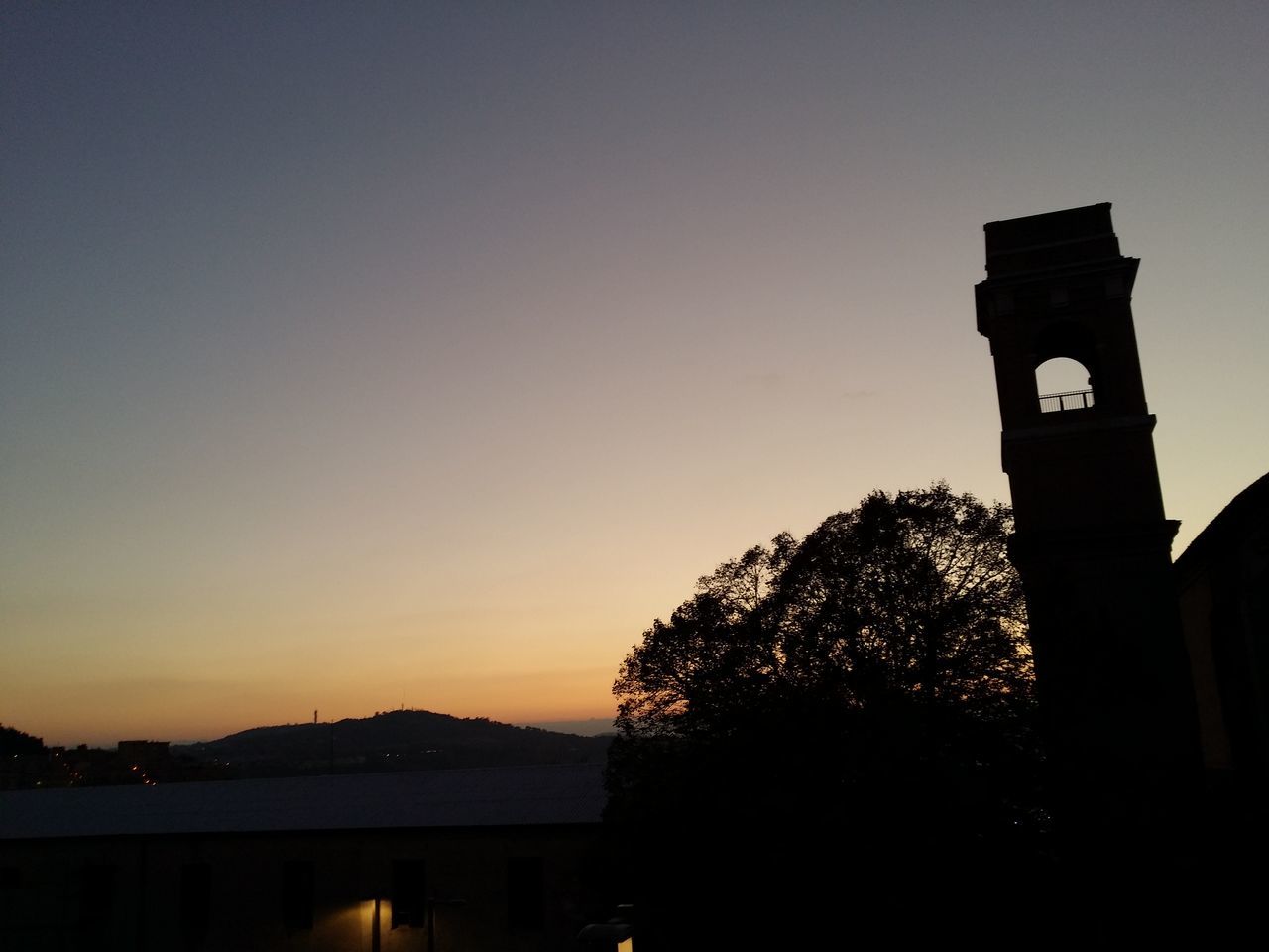 silhouette, sunset, clear sky, built structure, architecture, guidance, building exterior, copy space, tree, low angle view, tower, dusk, sky, communication, nature, orange color, outdoors, no people, tranquility, illuminated