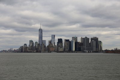 Modern buildings in city against cloudy sky