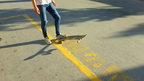 Low section of man skateboarding on road