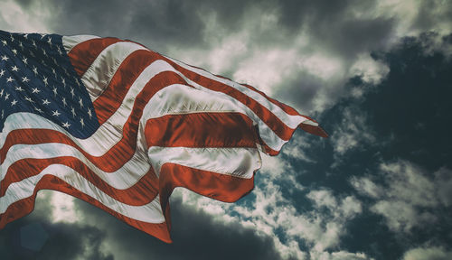 Low angle view of american flag against sky