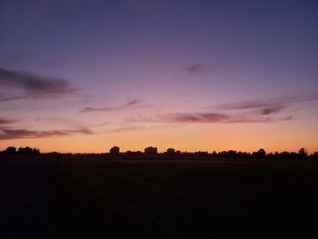 Scenic view of silhouette field against sky during sunset