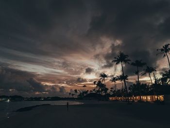 Silhouette palm trees on beach against sky during sunset