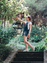 Full length of woman standing against plants