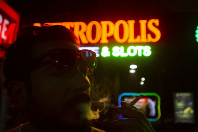 Close-up of man smoking cigarette at nightclub